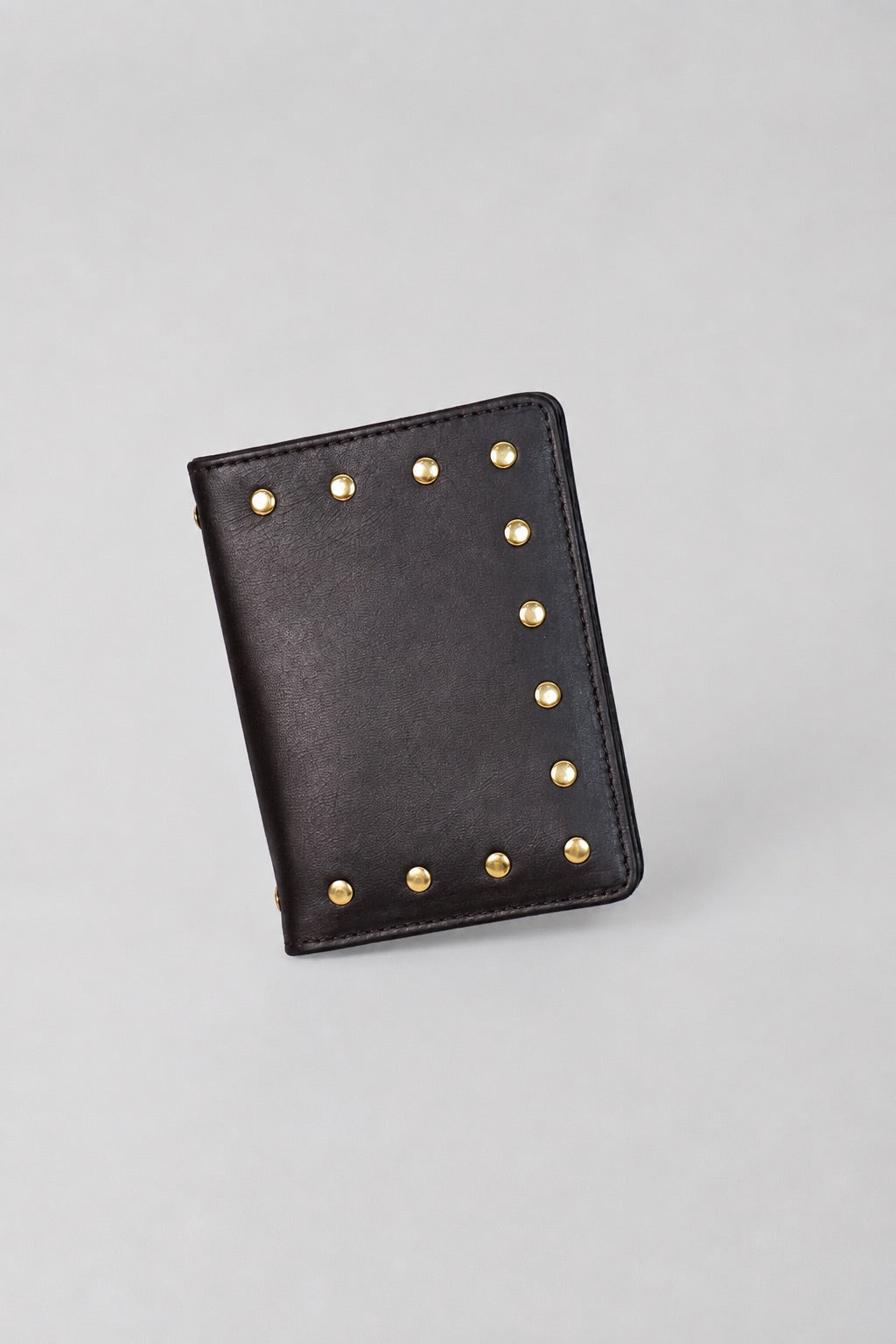 Dark brown leather Amaretto passport case by Violeta with gold studs, front view