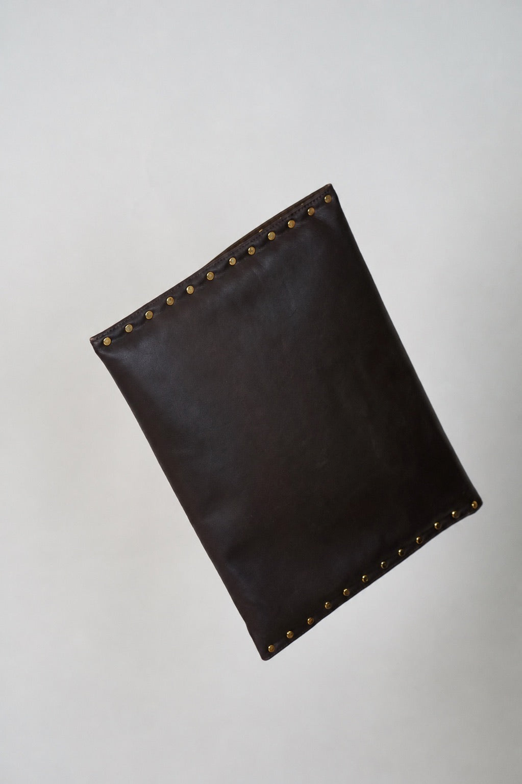 Back of the dark brown Amaretto laptop case with gold studs along the edges