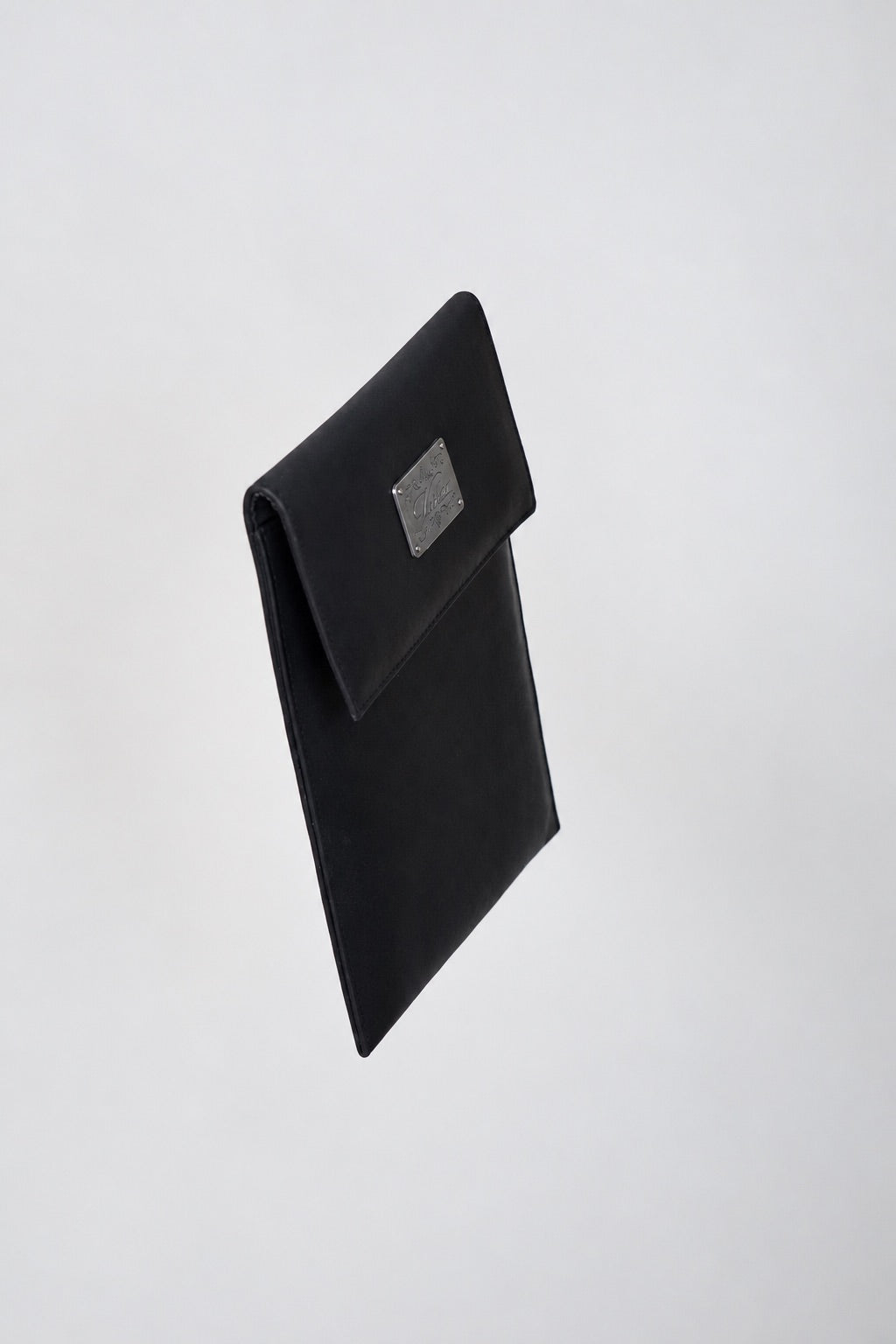Side angle of the black leather Shalom case showing its slim profile and engraved silver plate