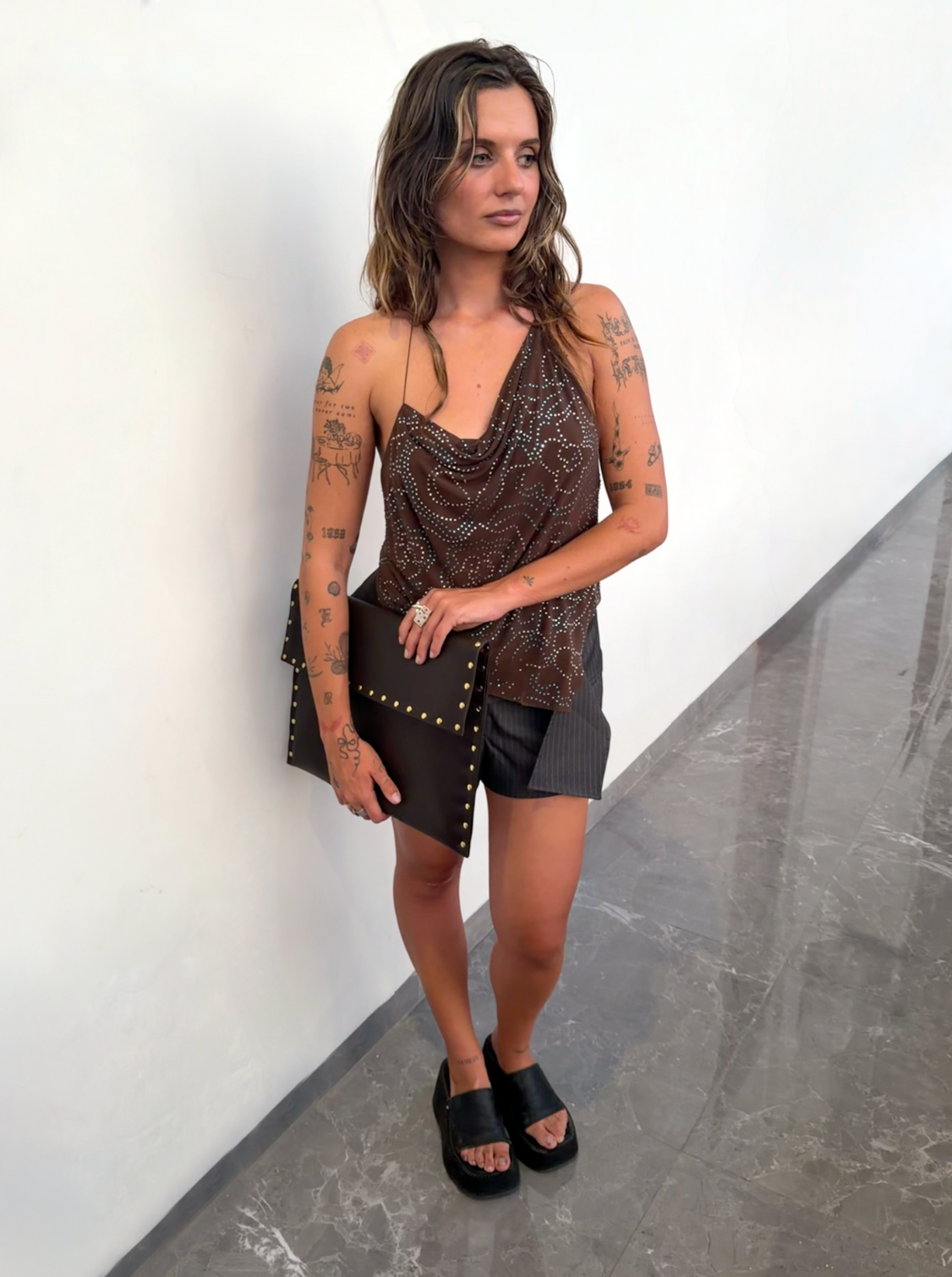 Woman in a brown halter top holding the Amaretto laptop case at her side